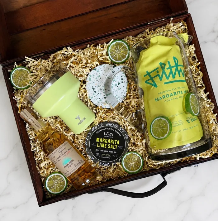 Beat the Heat gift box: a walnut keepsake case packed with a chartreuse tumbler, margarita mix, tequila, lime salt rimmer, and terrazzo coasters in gold crinkle paper.